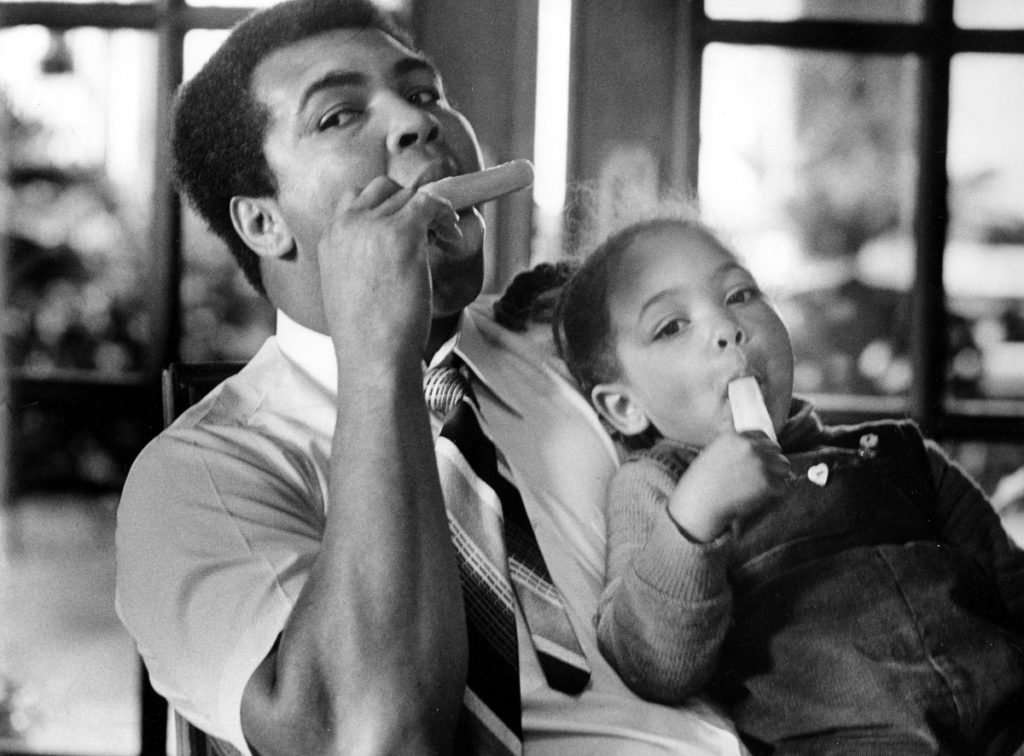 In Muhammad Ali's den, Hana, 3, shares a Popsicle with her father, who was handling the baby-sitting chores. Photo published Jan. 18, 1980. PUBLICATION PROHIBITED Authority to publish or copy MUST be obtained from Courier-Journal management. To obtain permission call 502-582-4601. 525 W. Broadway, Louisville, KY 40201. [Via MerlinFTP Drop]